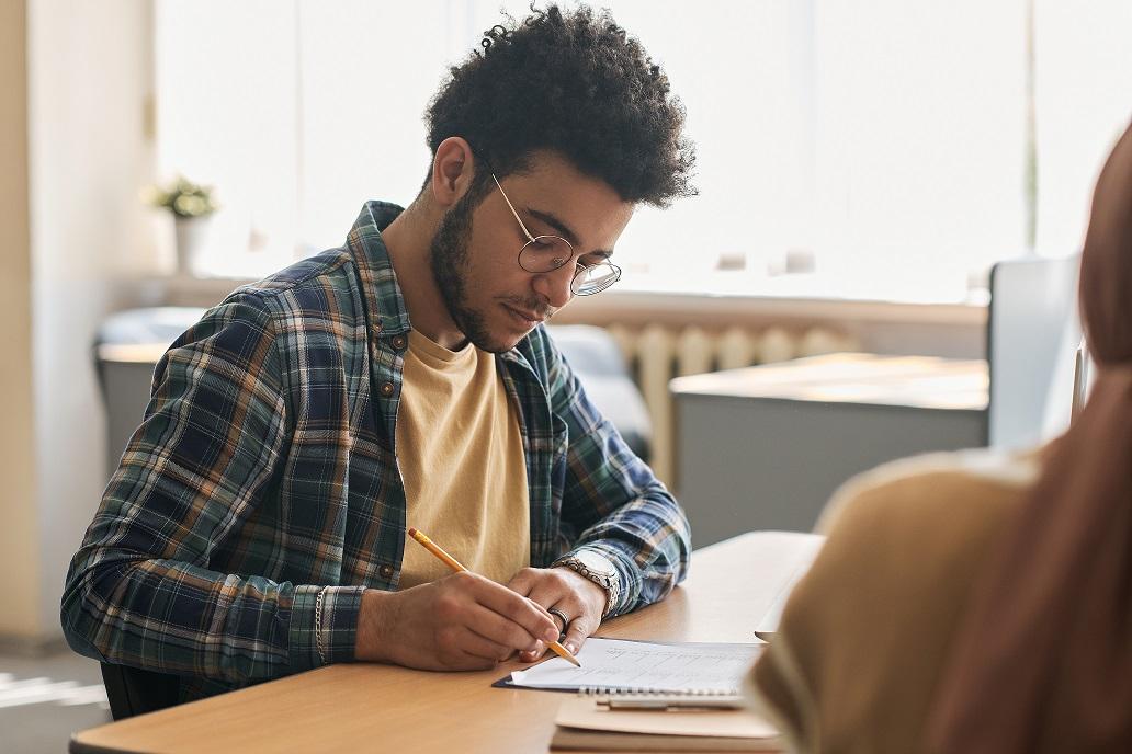 Teen student writing in classroom